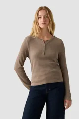 Remera de manga larga estilo Henley en color taupe melange, con cuello redondo y pechera con botones. Presenta un tejido de punto acanalado y un calce entallado.