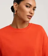 Blusa básica de mujer color negro, confeccionada en malla encorpada de algodón, con cuello redondo y mangas cortas de corte oversized con sisas desplazadas.