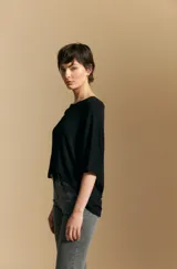 Remera de calce relajado con silueta fluida, confeccionada en tejido de viscosa con elastano. Presenta cuello redondo, mangas cortas y un diseño minimalista de caída suave.