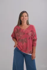 Sweter de punto amplio con escote en V y manga larga, presenta un diseño estampado de flores en tonos rojizos.