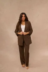 Blazer de sastreria color marron con solapa de muesca, bolsillos con solapa en el frente y mangas tres cuartos con trabilla y boton dorado.