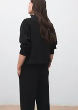 Buzo de cuello perkins y manga larga, con diseño recto y holgado. Confeccionado en tejido suave de modal y poliéster.