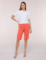 Bermuda entallada color naranja, de corte clásico tipo sastrero, con pretina ancha elastizada y detalles de herrajes en el ruedo.