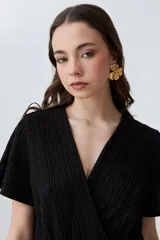 Mono largo negro con textura plisada, escote cruzado en V, mangas cortas con volados y pantalón palazzo.