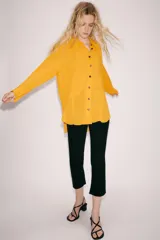 Camisa de viscosa color naranja de la colección ZW Collection de Zara, con cuello solapa, manga larga con puño, bajo asimétrico y cierre frontal con botones a contraste.