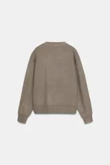 Jersey de punto liso con cuello redondo y manga larga, con detalle de costura en forma de V en el cuello.
