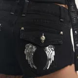 Short de denim negro con bolsillos traseros con solapa y detalle de alas bordadas con lentejuelas plateadas, tiro medio y bordes desmechados.