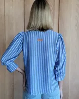 Blusa de algodón con cuello mao y volados, mangas largas con puños elásticos y corte holgado.