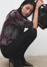 Jersey de punto con diseño de rombos (argyle) en tonos bordó, gris y blanco, de manga larga y cuello redondo.