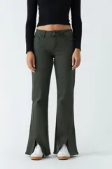 Pantalón oxford verde militar de tiro medio, ajustado en la cadera y piernas que se ensanchan. Presenta cortes en el bajo de cada pierna.