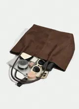 Bolso tipo tote de diseño minimalista en color negro, con textura suave y doble asa larga para llevar al hombro.