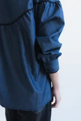 Camisa negra de manga larga con canesú estampado con diseño floral, cuello camisero y cierre frontal con botones.