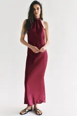 Vestido largo satinado de color bordó, con cuello halter fruncido y diseño sin mangas.