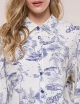 Conjunto de dos piezas de algodón y lino, con estampado estilo Toile de Jouy en color marrón sobre fondo off-white. Incluye camisa de manga corta amplia con cuello camisero y short tiro alto con elástico en la cintura y bolsillos.
