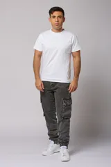 Pantalón jean gris oscuro de corte jogger con bolsillos cargo laterales y puños elásticos en los tobillos.