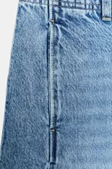 Jeans de tiro medio con pernera holgada tipo barrel que se estrecha hacia el tobillo, acabado con bajo sin costura, bolsillos delanteros y bolsillos de plastrón en la espalda. Cierre frontal con cremallera y botón.