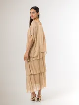 Vestido largo color beige de seda italiana, con falda de volados y sobrecapa superior. Confeccionado en tejido liviano y fluido con diseño elastizado.