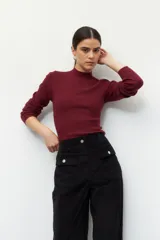 Pantalón de pana color verde oliva, de tiro alto y corte recto. Cuenta con cuatro bolsillos, los delanteros con solapa y botón metálico.