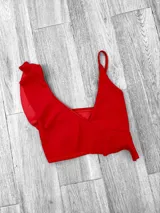 Top de bikini fucsia con un solo tirante y volados en el escote.