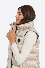 Chaleco largo azul con capucha desmontable, cierre central con cremallera de doble carro y bolsillos con tapa. Diseño acolchado a rayas horizontales. Largo 86cm.