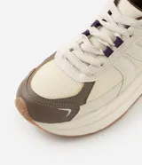 Championes de estilo jogging marca Satinato, con diseño de paneles superpuestos en material sintético y tejido respirable. Presentan suela gruesa, cierre con cordones y tirador trasero.