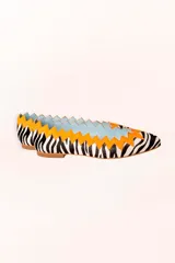 Bailarinas con estampado animal print de cebra, puntera fina y detalle de ante naranja en zigzag en el borde superior. Interior celeste y suela de cuero.