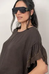 Blusa de lino color tostado, de corte holgado y manga corta con inserción de puntilla bordada.