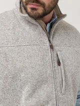 Chaleco de hombre con exterior tejido jaspeado e interior de micropolar. Cuenta con cierre frontal completo, cuello alto y tres bolsillos frontales con cierre.