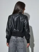 Campera bomber de eco cuero negro, con cierre frontal plateado, cuello, puños y cintura elastizados en rib.