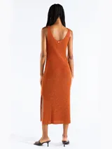 Vestido midi sin mangas confeccionado en punto jersey de tejido italiano con hilo Lurex en dos colores que aporta brillo sutil. Presenta escote bote redondeado y aberturas laterales.