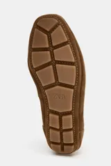 Bailarina deportiva de serraje color marrón, con diseño de doble tira en el empeine, una elástica y otra con cierre adhesivo. Presenta costuras decorativas en el cuerpo, suela plana y punta redonda.
