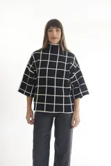 Sweater de punto con cuello alto y manga corta, con estampado de cebra en blanco y negro.