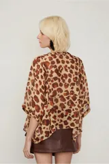 Camisa de manga corta con estampado animal print, cuello bote, abotonada en el frente y de fit amplio.