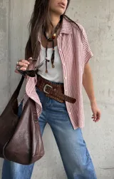 Camisa de manga corta con diseño a rayas rojas y blancas, cuello clásico y cierre frontal de botones.