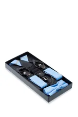 Set de tirantes con moño y pañuelo de bolsillo, color azul con estampado floral en tonos grises. Los tirantes son ajustables y tienen apliques para abrochar a botones o pinzas metálicas para sujetarlos al pantalón.