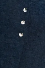 Chaleco azul de lino con cuello redondo y sisas. Cierre frontal cruzado con botones plateados.