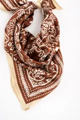 Bandana de diseño cuadrado en tono marrón y blanco con estampado de arabescos y flores, con bordes en color marfil.