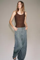 Jeans de tiro medio con corte barrel, confeccionados en denim con estampado floral integral. Presentan diseño de cinco bolsillos, cintura con trabillas y cierre frontal con cremallera y botón.