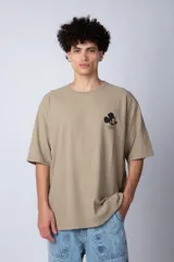 Remera negra de corte oversize confeccionada en algodón pesado, con estampa pequeña de Mickey Mouse en el pecho y diseño gráfico en la espalda.
