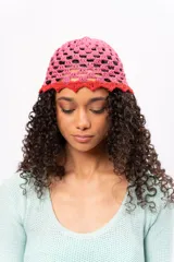 Gorro tipo bucket tejido a crochet, color rosa con borde rojo.