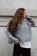 Buzo tejido en mohair de corte crop, con cuello redondo y tajos laterales. Diseño holgado con mangas largas.