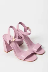 Sandalias de tacón alto color lila, con tira delantera y tobillera con hebilla dorada.