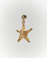 Dije de oro con forma de estrella de mar y un pequeño brillante incrustado.