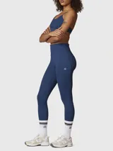 Conjunto deportivo compuesto por un top de breteles finos con banda elástica inferior en contraste y calzas de tiro alto con bolsillos laterales.