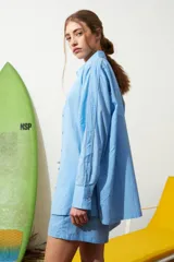 Camisa celeste de poplin con ribete decorativo en los bordes.