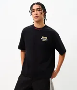 Remera boxy de algodón negro con mangas cortas y cuello redondo, con bordados en rojo y blanco con tipografía japonesa y diseño gráfico en la espalda.