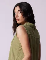 Blusa color crema sin mangas, con cuello camisero, cierre frontal con botones y bolsillo de crochet.