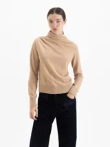 Sweater de lana merino color negro, con cuello medio alto y detalle de frunces en los hombros que aportan volumen. De calce regular y tejido suave.