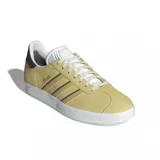 Championes adidas modelo Gazelle, confeccionados en gamuza color amarillo con las icónicas tres tiras laterales en marrón. Presentan suela de goma blanca, lengüeta blanca y detalle en el talón en color marrón oscuro.