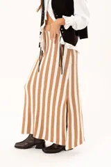 Falda larga tejida a rayas verticales color beige y blanco, con pretina elástica y tajos laterales.